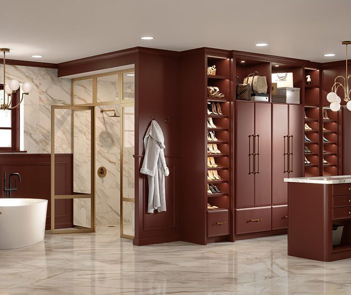 Modern luxury dressing room with burgundy cabinets, marble floor, gold-framed mirrors, and built-in shoe storage
