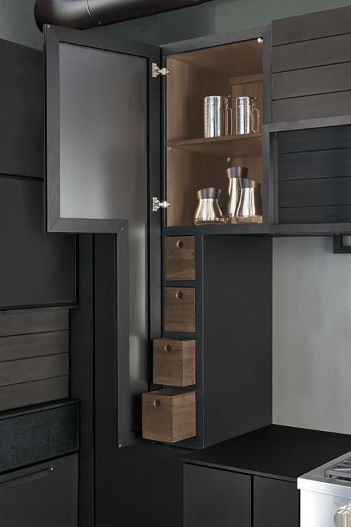 Open kitchen cabinet with pull-out drawers, shelves, and glassware in gray and wood tones