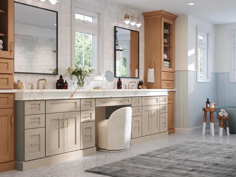 Bright bathroom with double vanity, mirrors, white cabinets, and gray tile floor, plus a small stool and children’s sink set