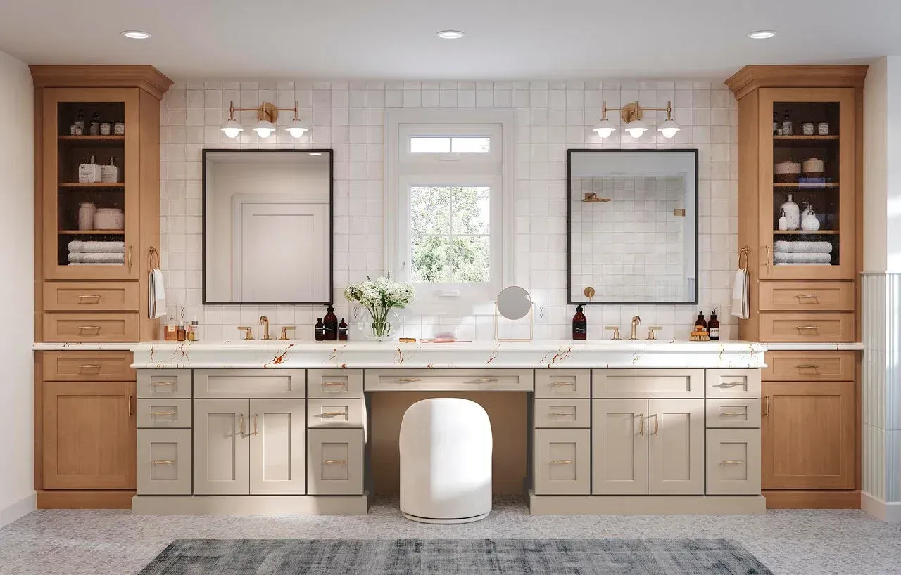 Bright double vanity bathroom with wood cabinets, large mirrors, and a white bathtub in the center