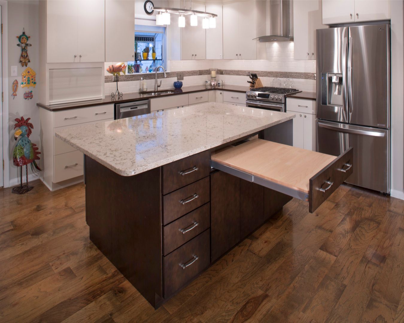 Modern kitchen with granite island, dark wood cabinets, stainless steel appliances, and hardwood floors