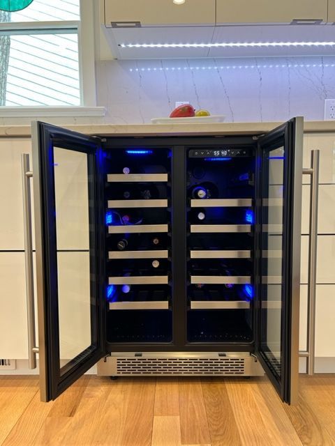Open cabinet with rows of glowing blue-lit wine bottles on shelves indoors