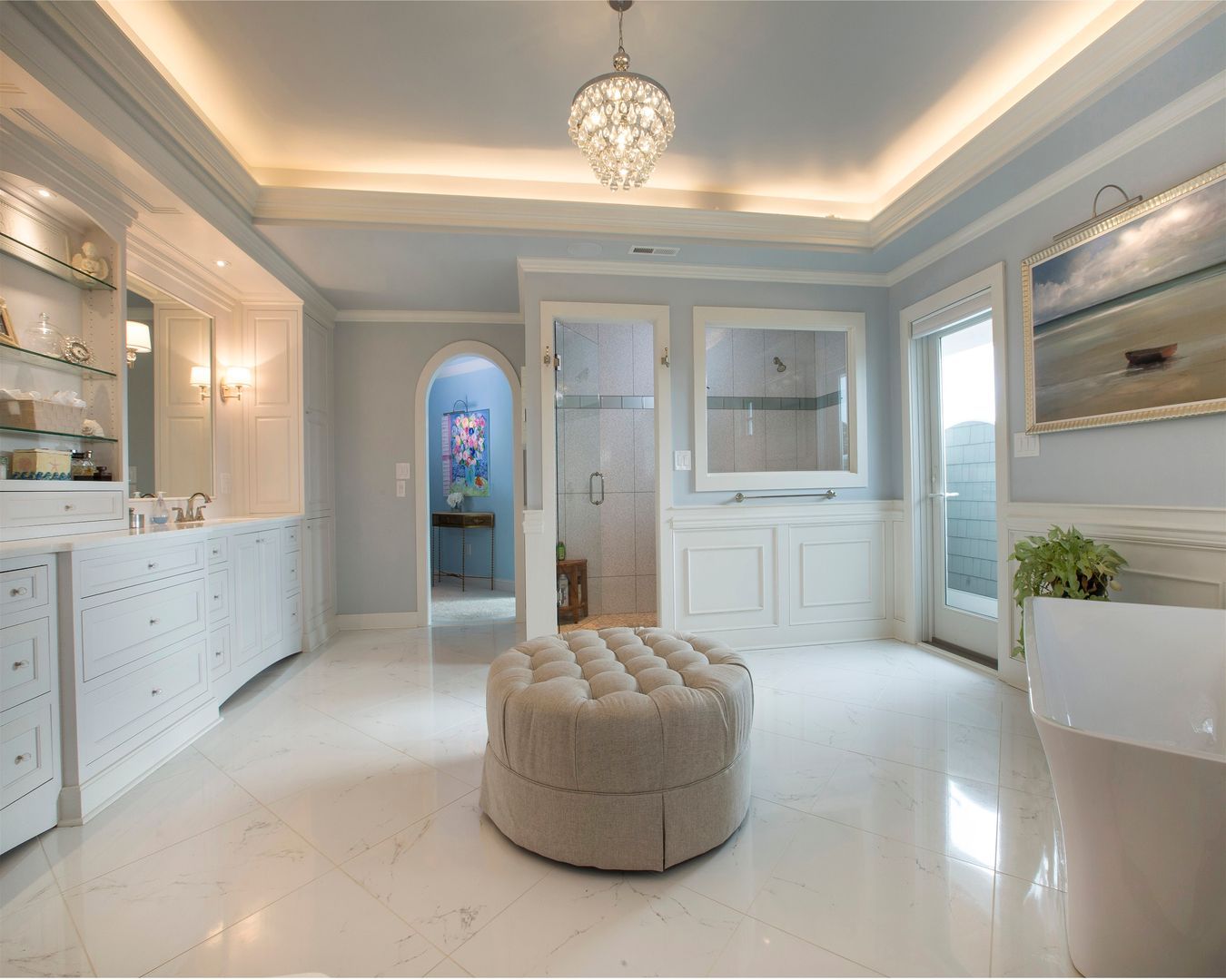 A large bathroom with a round ottoman in the middle