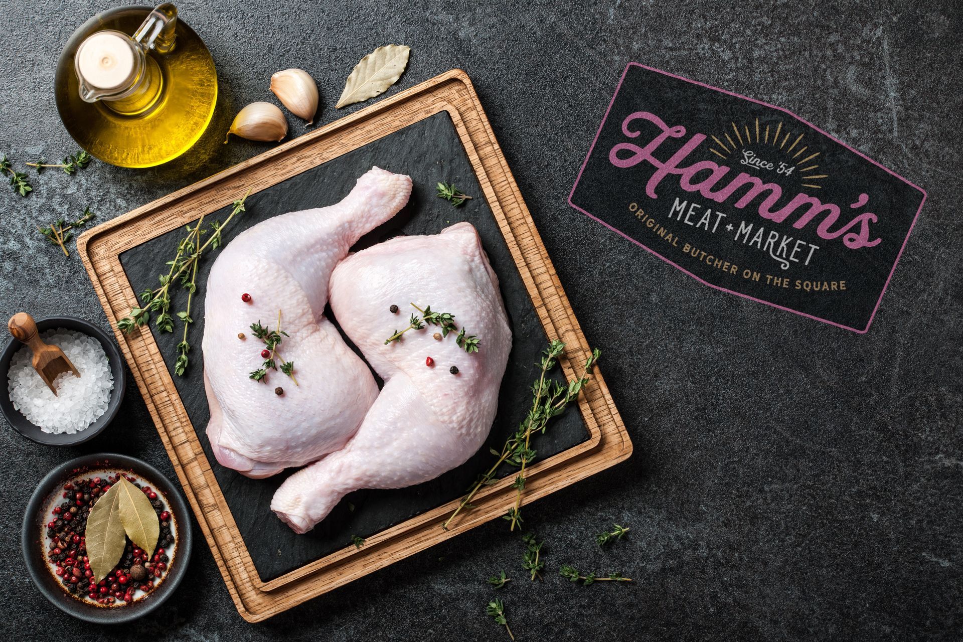Raw chicken legs on a wooden cutting board with spices.