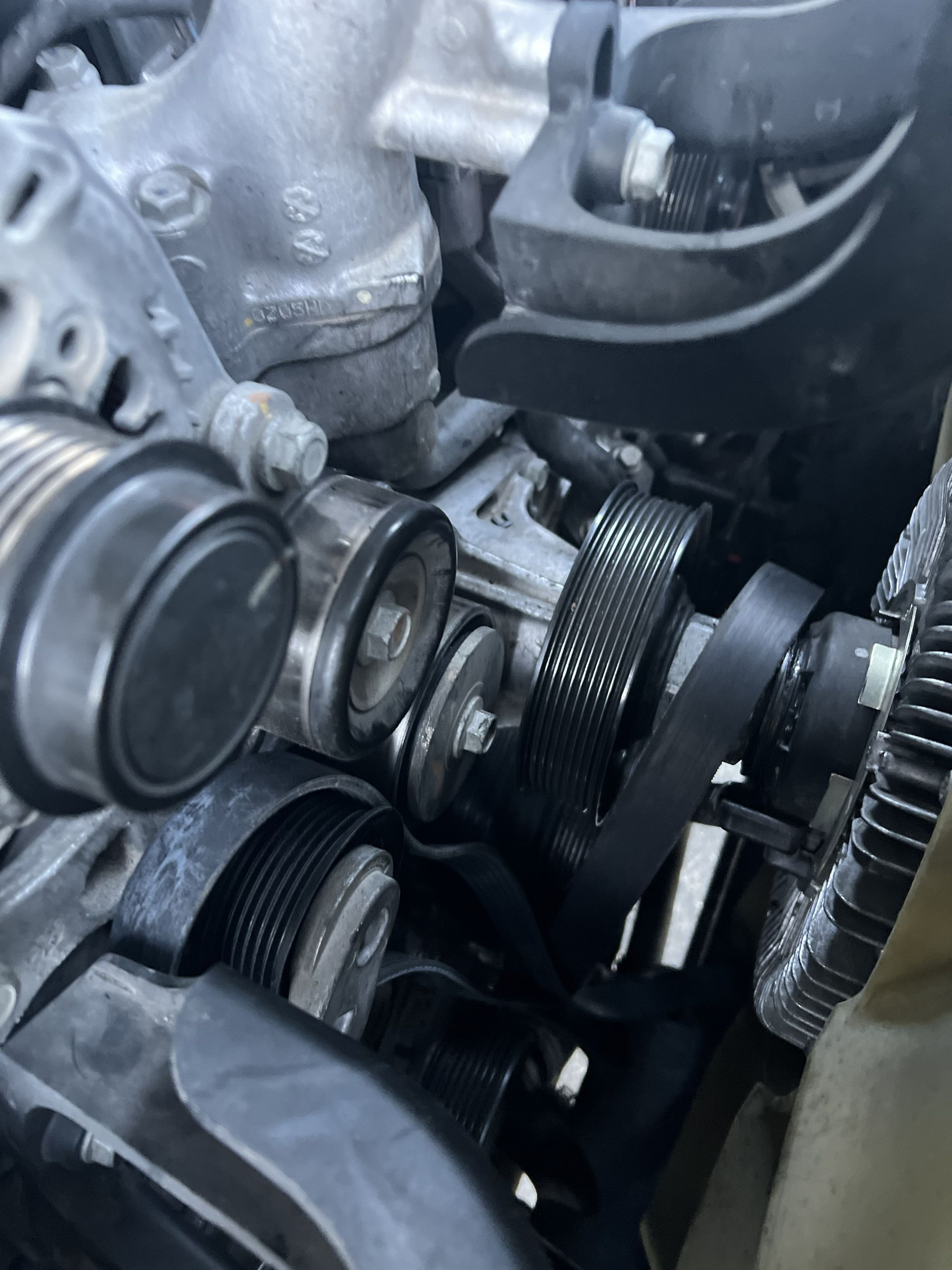 Close-up of an engine’s belt and pulleys inside a car engine bay