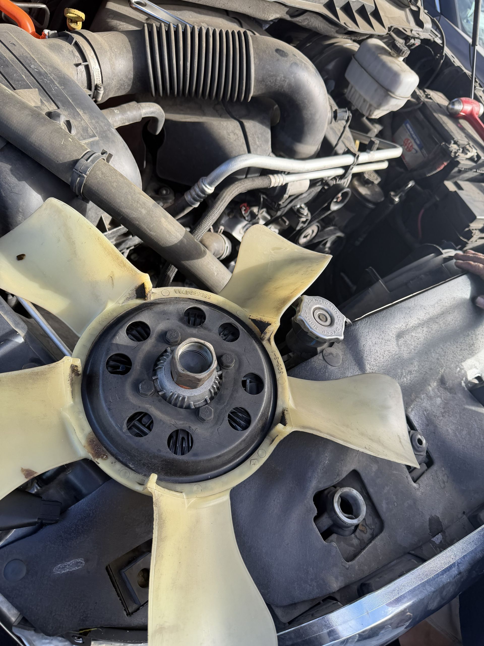 Close-up of a car engine fan and belt assembly inside the engine bay