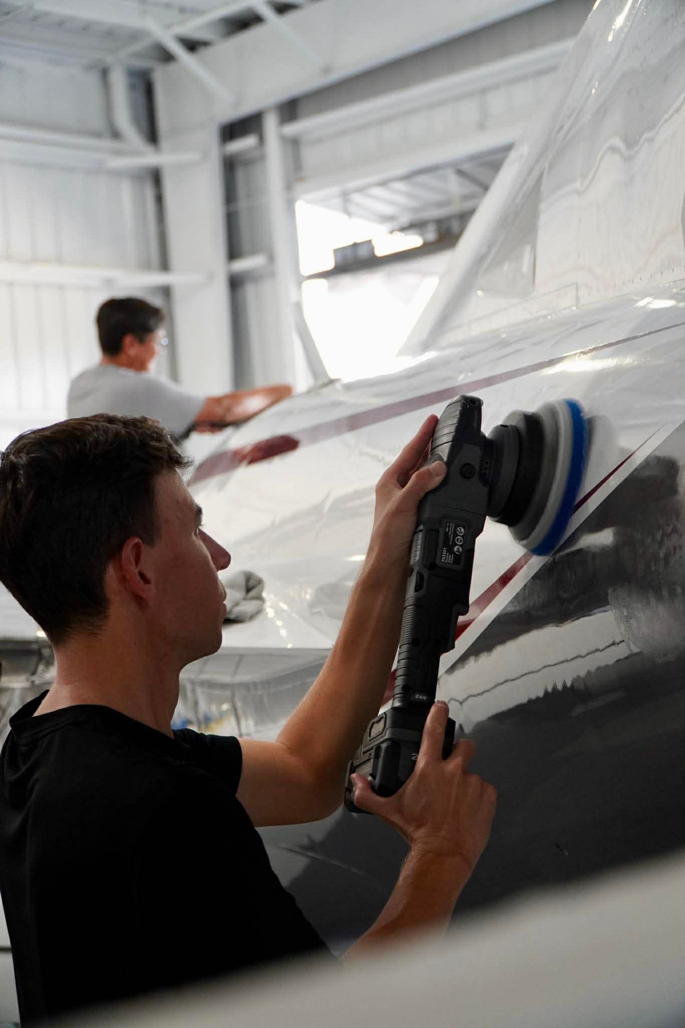 Person polishing an RV, with