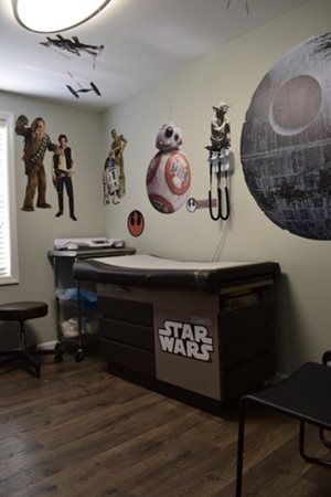 Star Wars-themed room with wall decals, figurines, and a Star Wars storage bench.