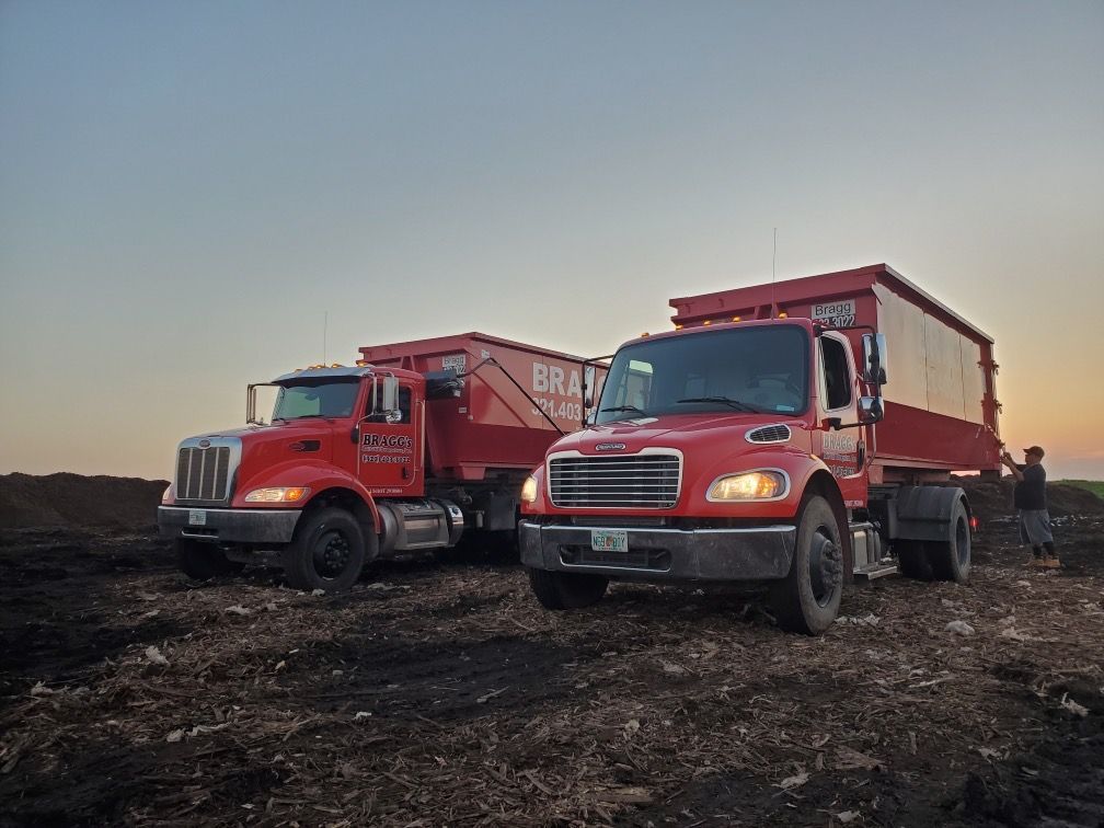 Two Red Dumpster Trucks — Melbourne, FL — Braggs Roll-Off Dumpsters Inc.