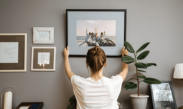 There is a painting on the wall above the bed.