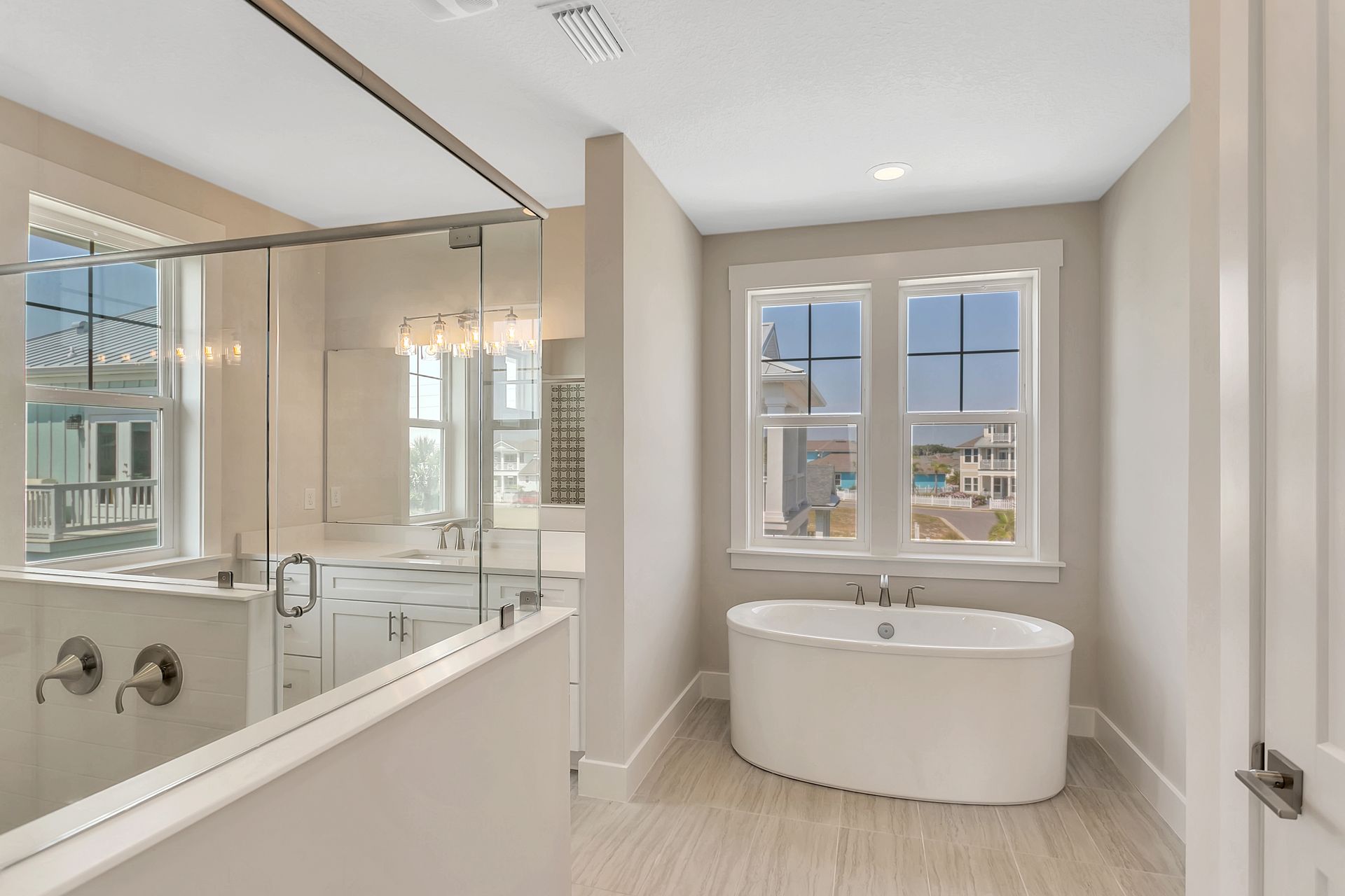A bathroom with a bathtub and a large mirror.