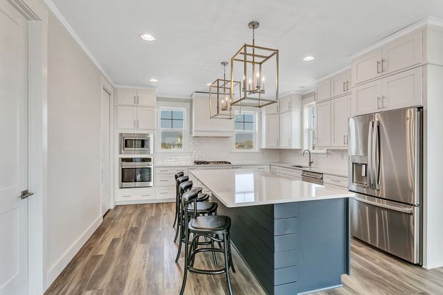 A kitchen with stainless steel appliances and a large island.