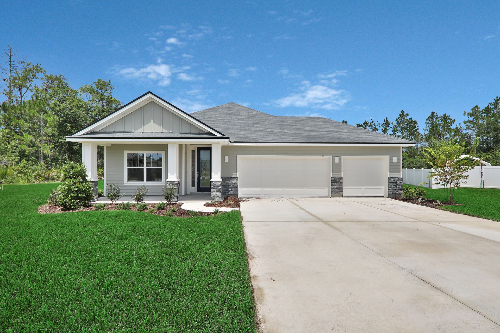 A house with a driveway and a lot of grass in front of it.