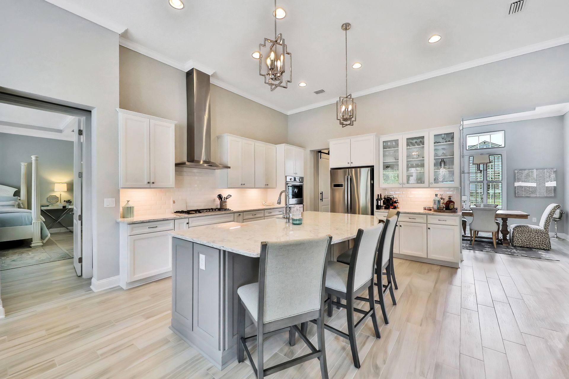 A kitchen with white cabinets , stainless steel appliances and a large island.