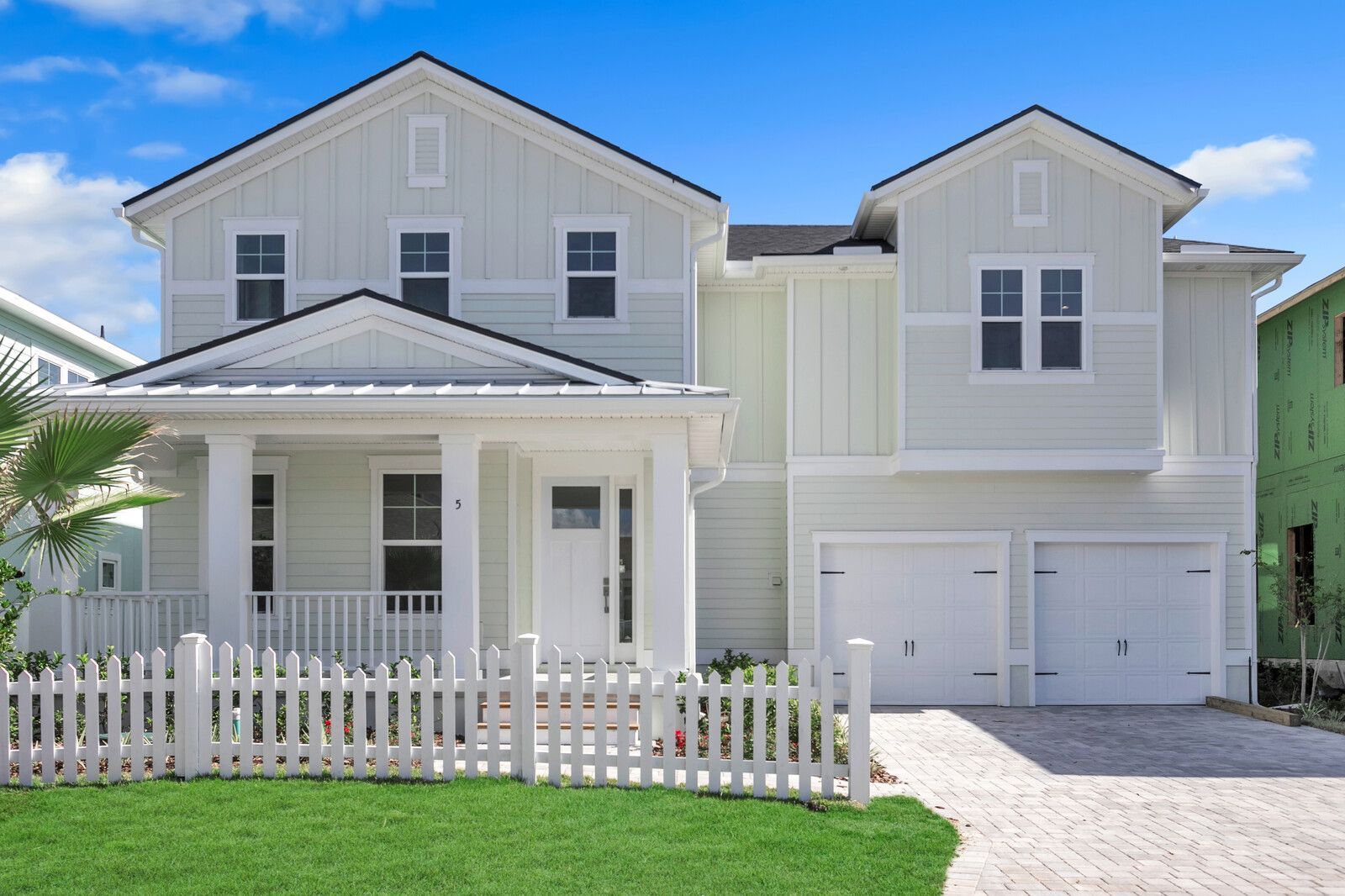 A large white house for sale with a white picket fence in front of it in Beach Haven in Palm Coast.