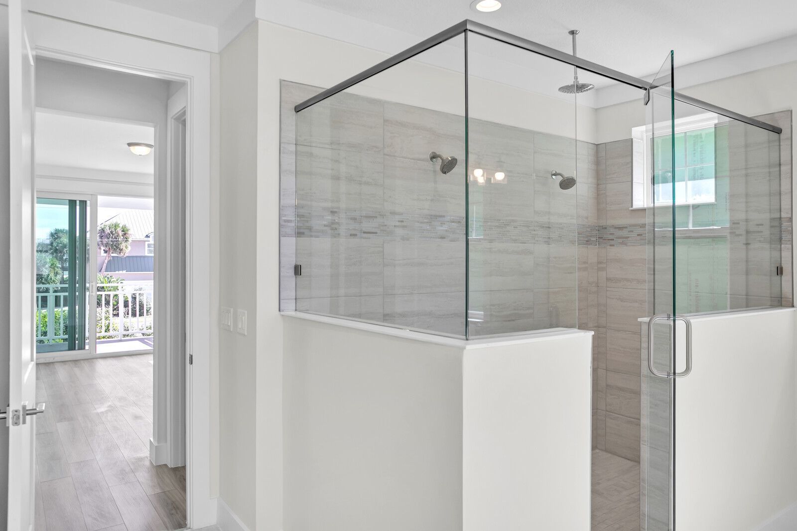 A bathroom with a walk in shower and a sliding glass door.
