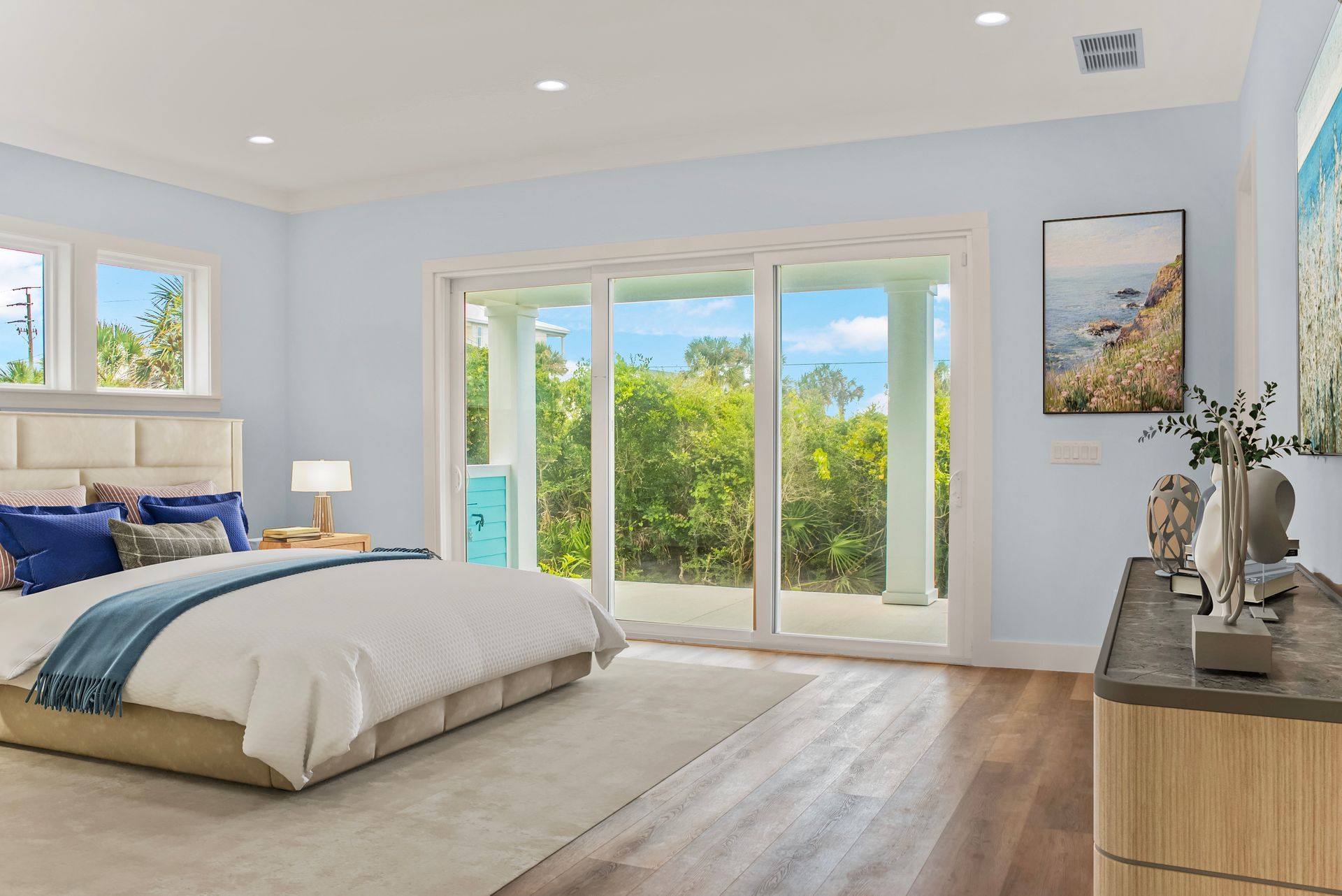 A bedroom with a large bed , dresser , and sliding glass doors.