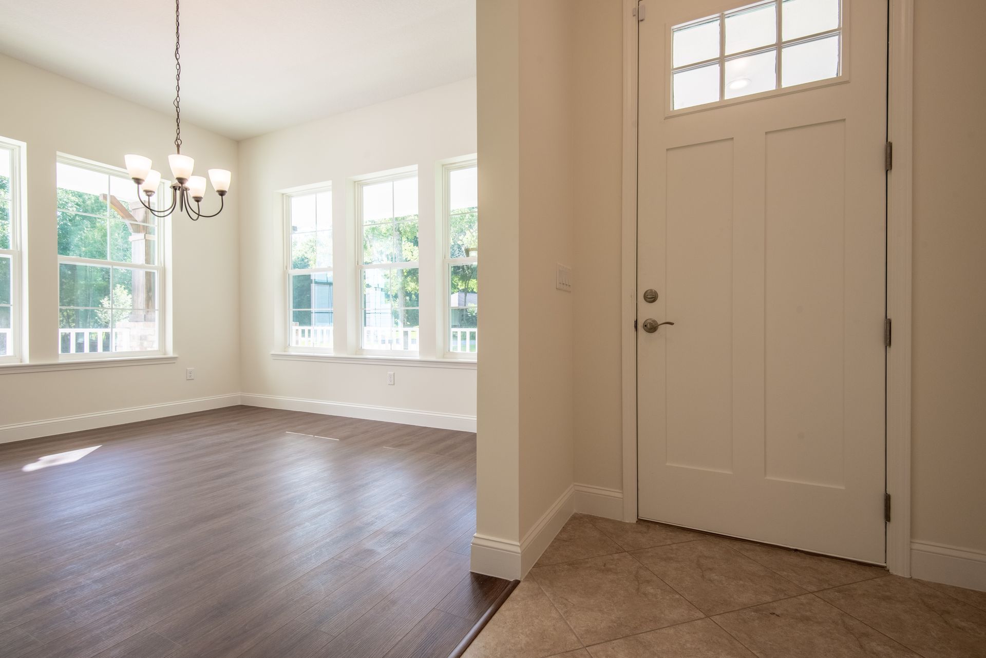 An empty room with hardwood floors and a white door
