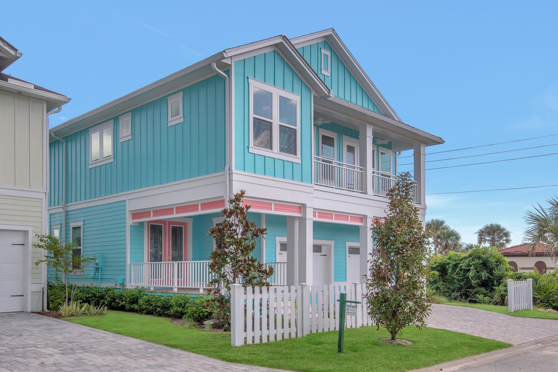 A blue and white house with a white picket fence
