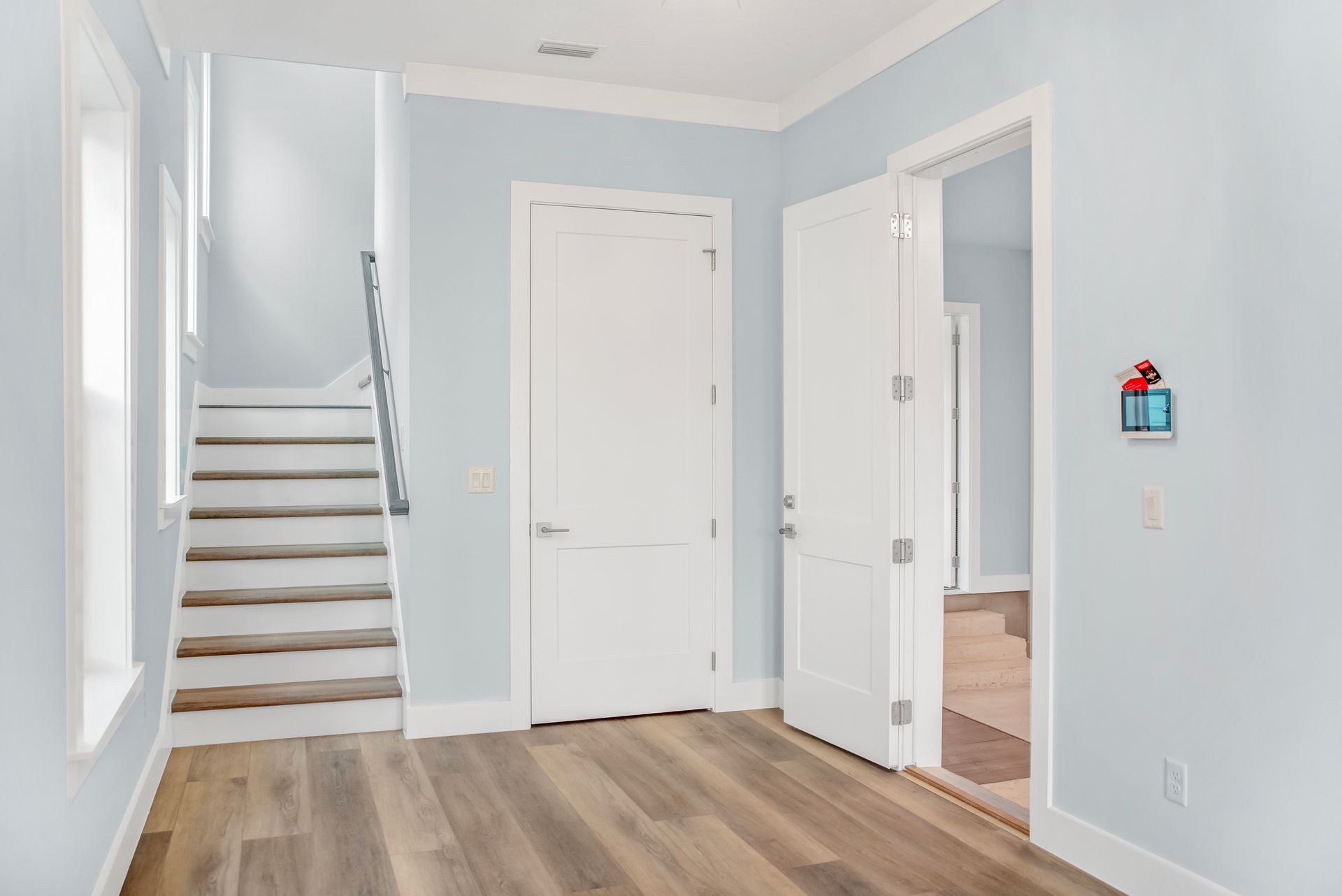A hallway with stairs leading up to the second floor of a house.