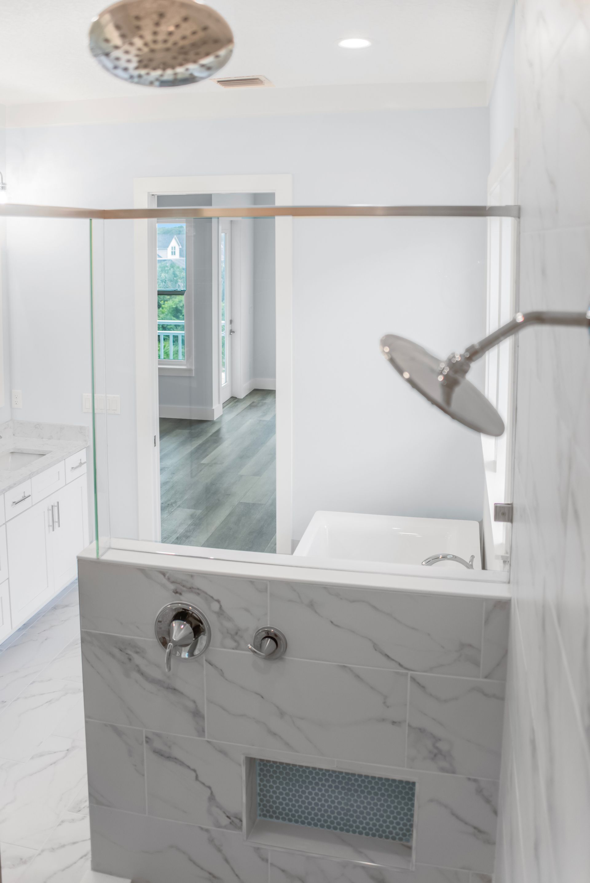 A bathroom with a walk in shower and a tub.