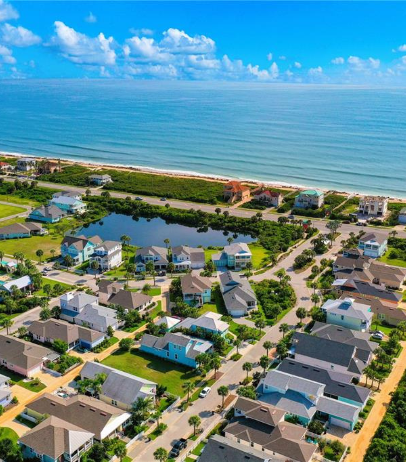 An aerial view of a residential area next to the ocean.