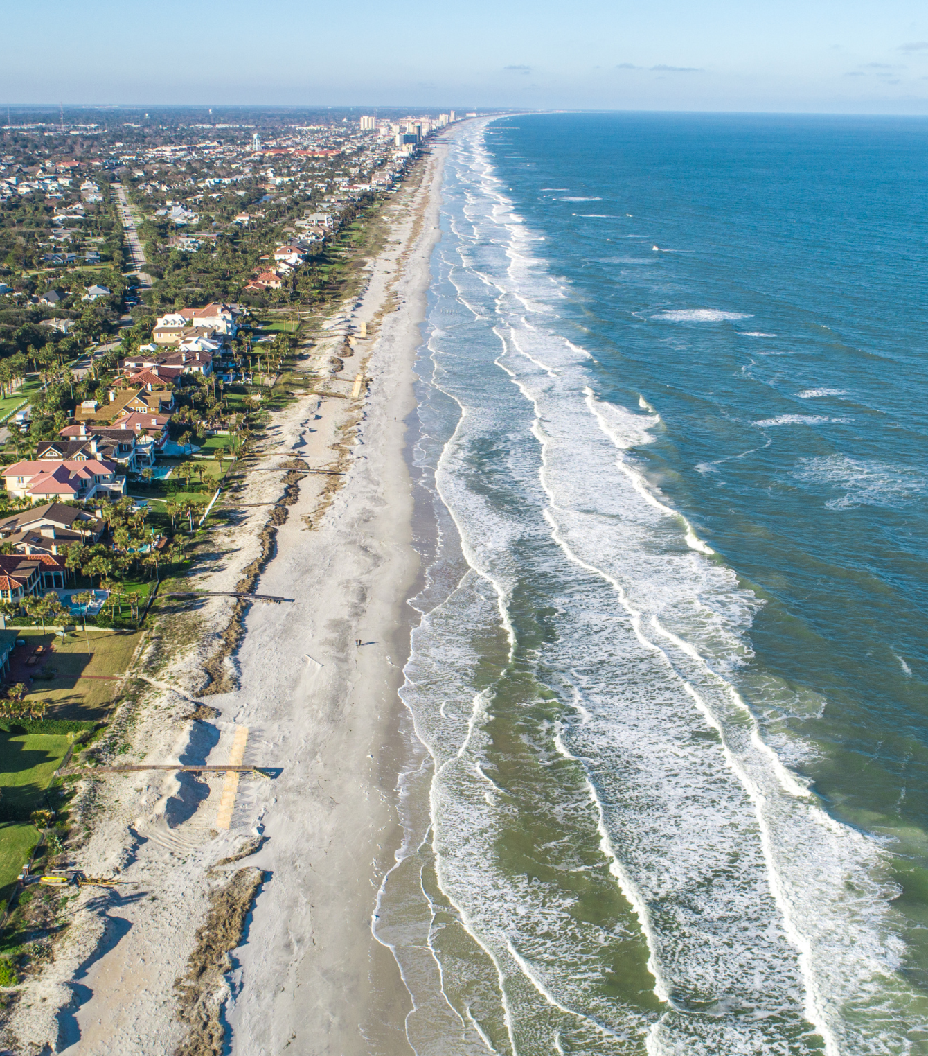 An aerial view of a beach with waves crashing on it
