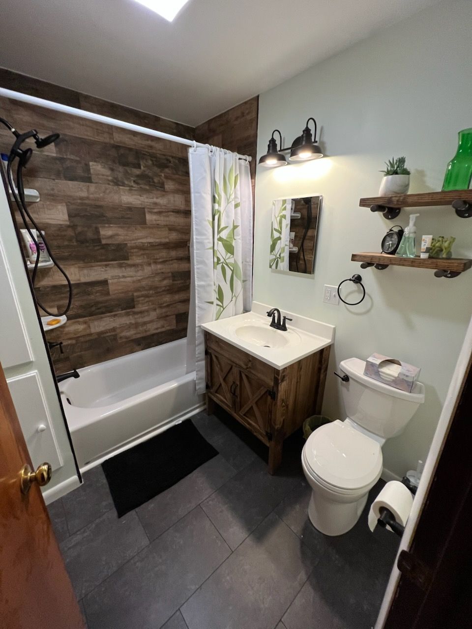 Bathroom with wooden accents. Tub with wood-look wall.