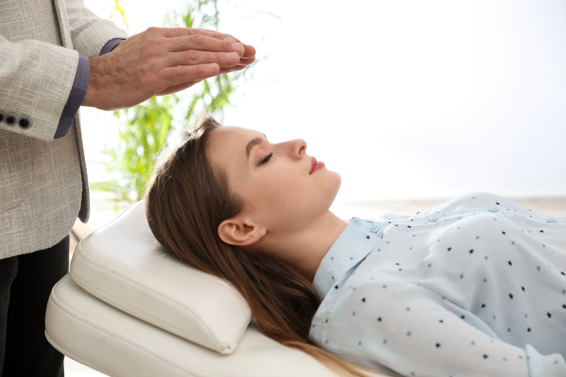 Hands massaging a back; close-up, oils visible, on a massage table.