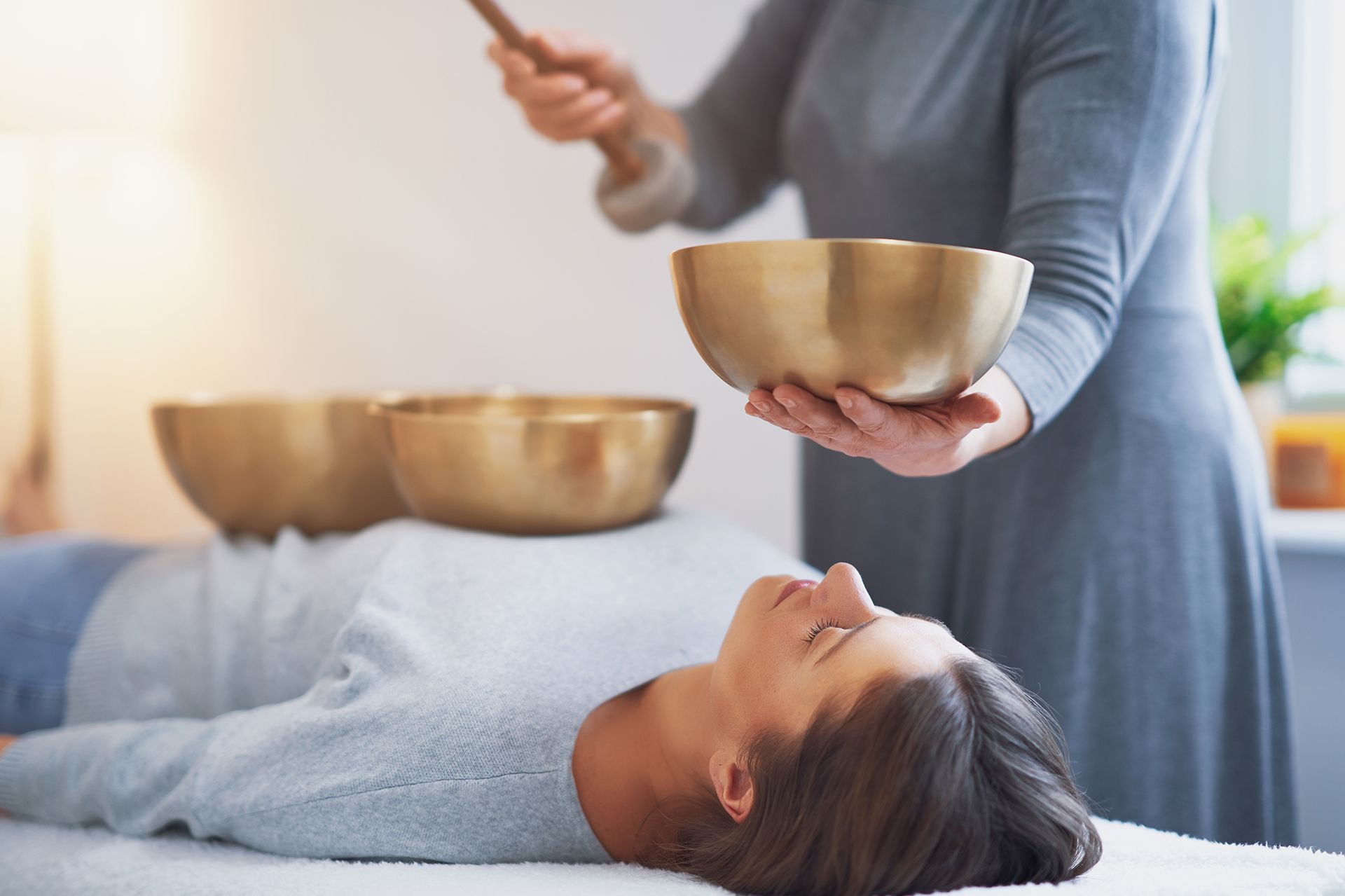 Hands massaging a back; close-up, oils visible, on a massage table.