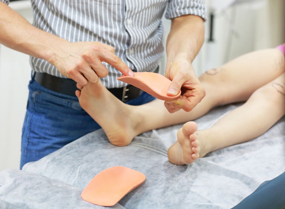 A Person Is Laying On A Bed While A Doctor Examines Their Foot — Sandy Gugenberger Podiatrist in Port Macquarie, NSW