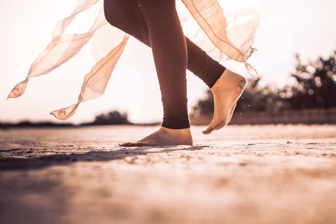 A Woman Is Walking Barefoot On A Dirt Road — Sandy Gugenberger Podiatrist in Port Macquarie, NSW