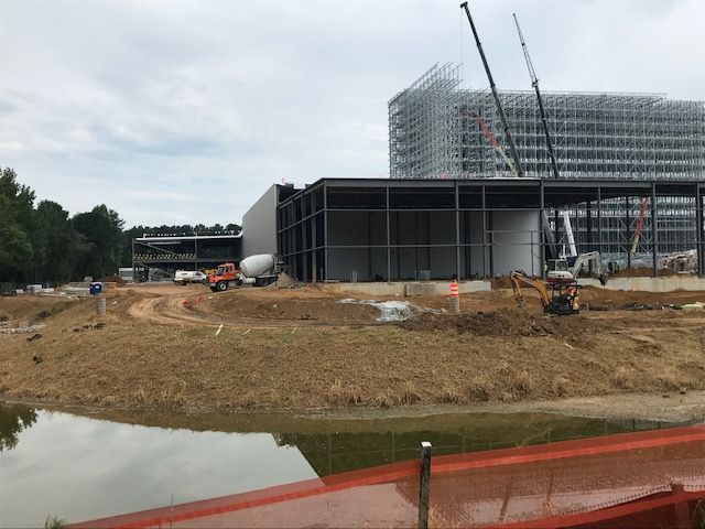 A large building is being built next to a body of water.