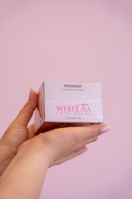 Una donna tiene in mano una scatola di tè bianco.