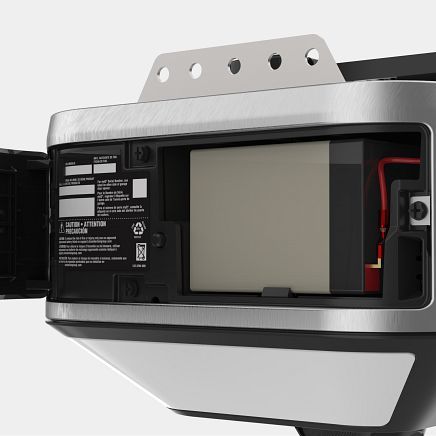Garage door opener with a rectangular battery visible inside the unit, wires connected.