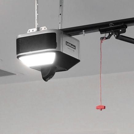 Garage door opener with attached light and red emergency pull cord.
