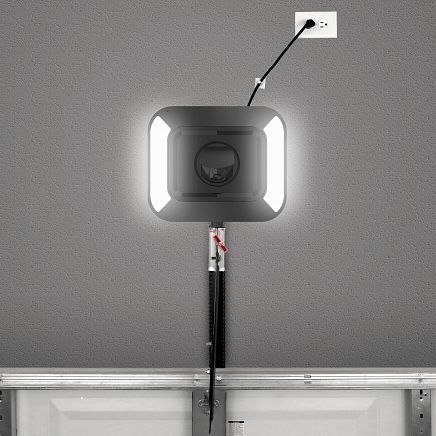 Gray garage door opener with LED lighting, plugged into a wall outlet.