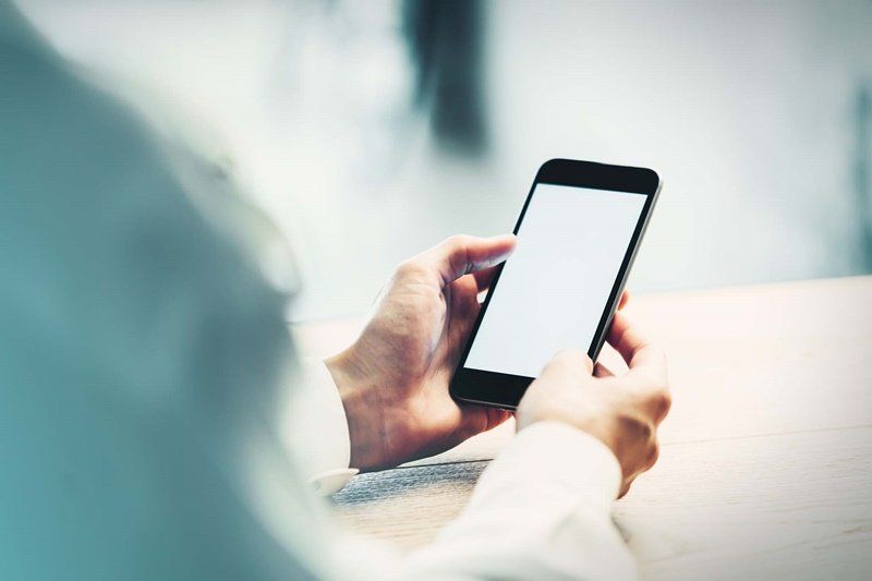 uma pessoa está segurando um telefone celular nas mãos.