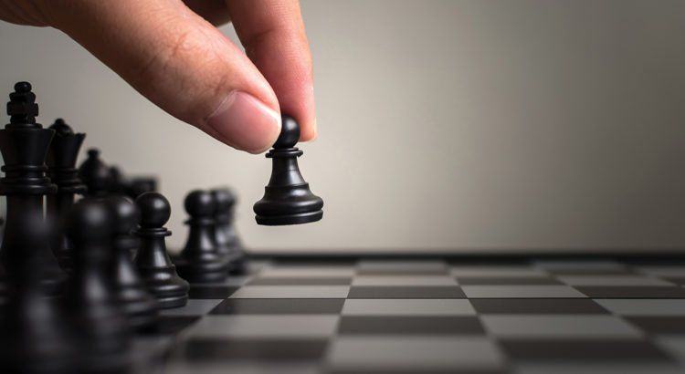 Uma pessoa está jogando xadrez em um tabuleiro de xadrez.