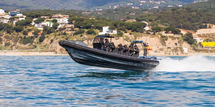 A large boat is speeding on top of a body of water.
