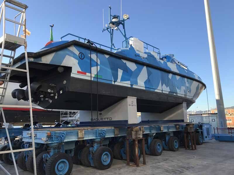 A large blue and white boat is sitting on a trailer
