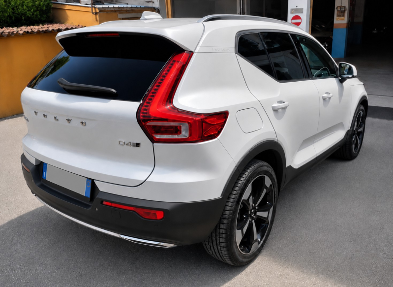SUV bianco parcheggiato all'aperto, vista posteriore a tre quarti, con finiture nere e fanali posteriori rossi.