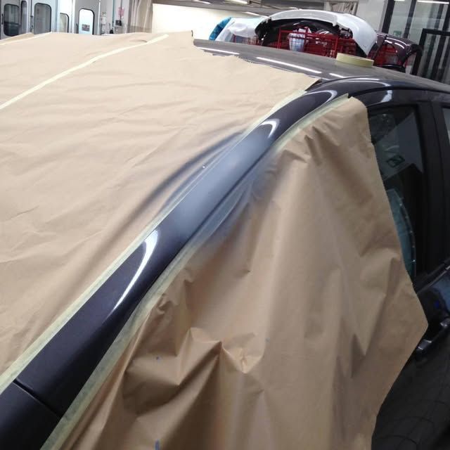 Auto ricoperta con carta da mascheratura beige per la verniciatura, con tetto e bordi dei finestrini a vista.