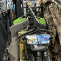 Racks of camouflage hunting waders and gear hanging in a store aisle