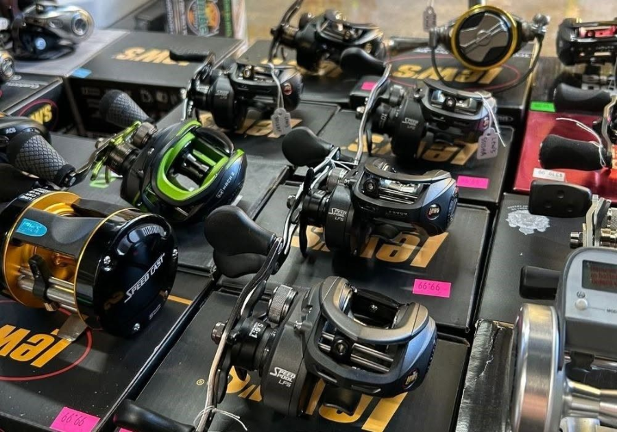 Rows of colorful fishing reels displayed on a retail shelf