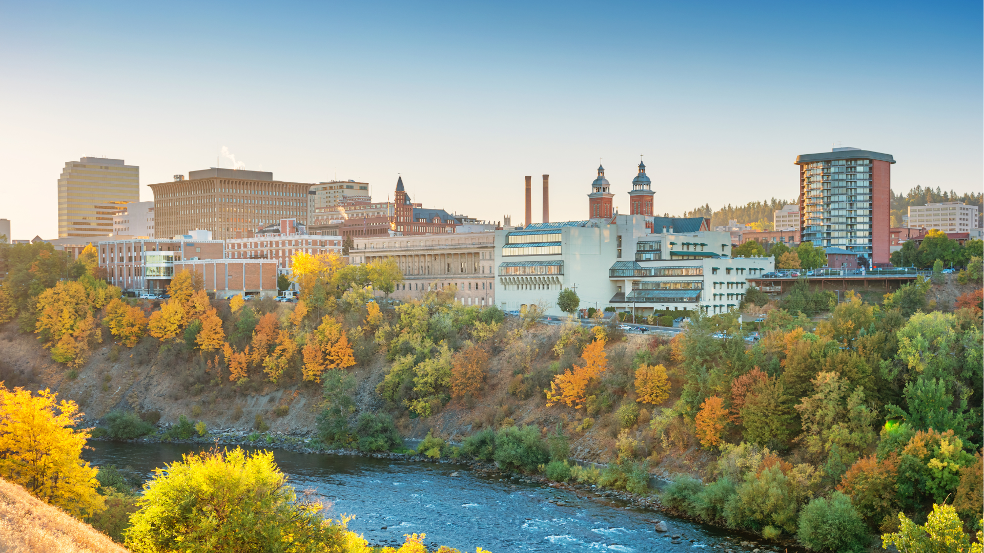 A river runs through a city surrounded by trees and buildings.