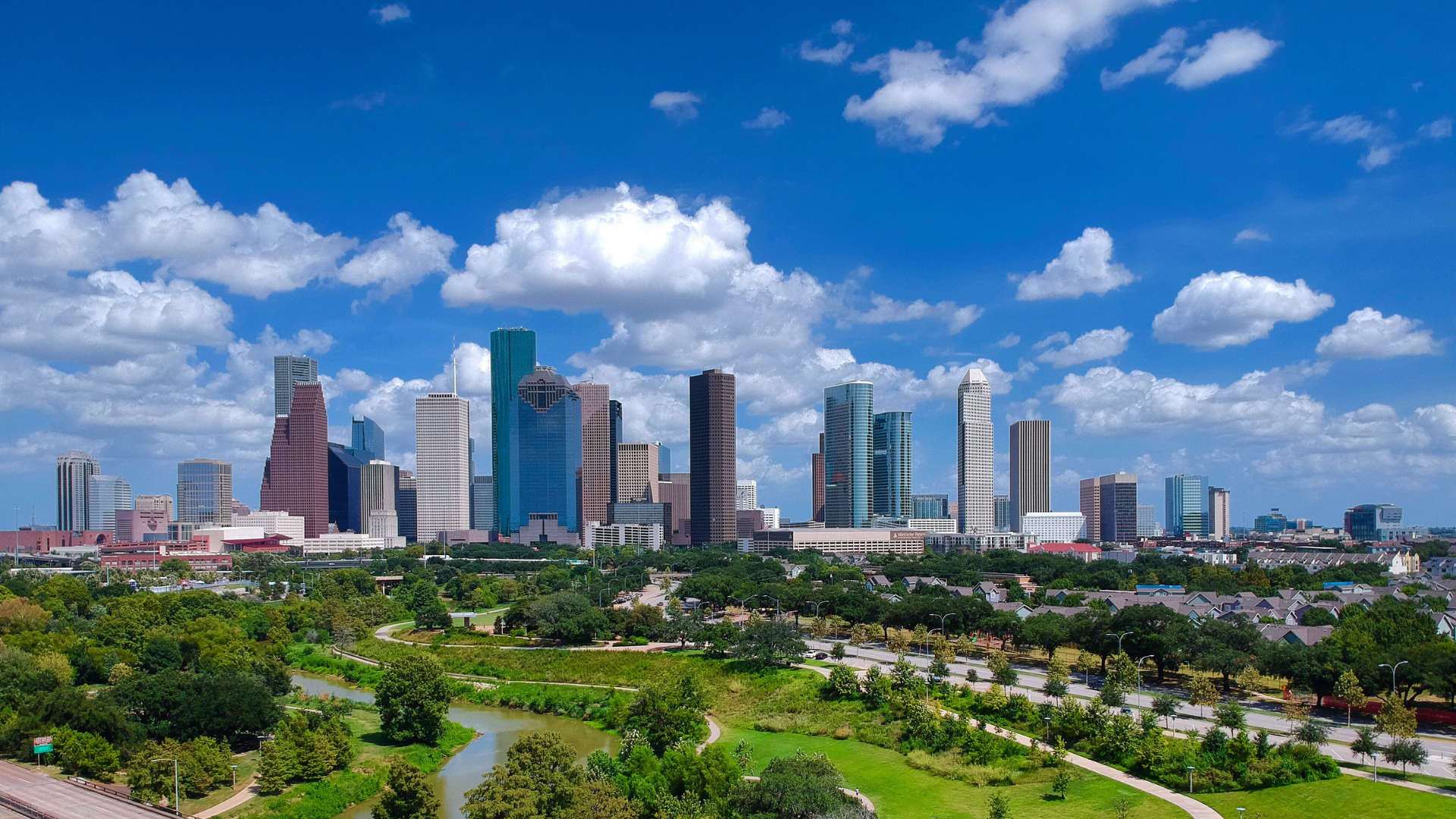 An aerial view of a city skyline with a park in the foreground.