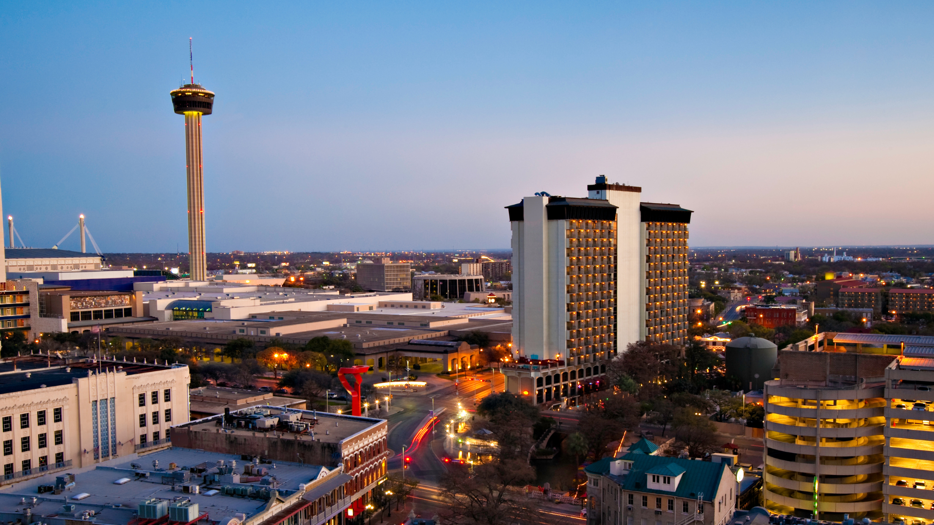 An aerial view of a city with a tower in the background