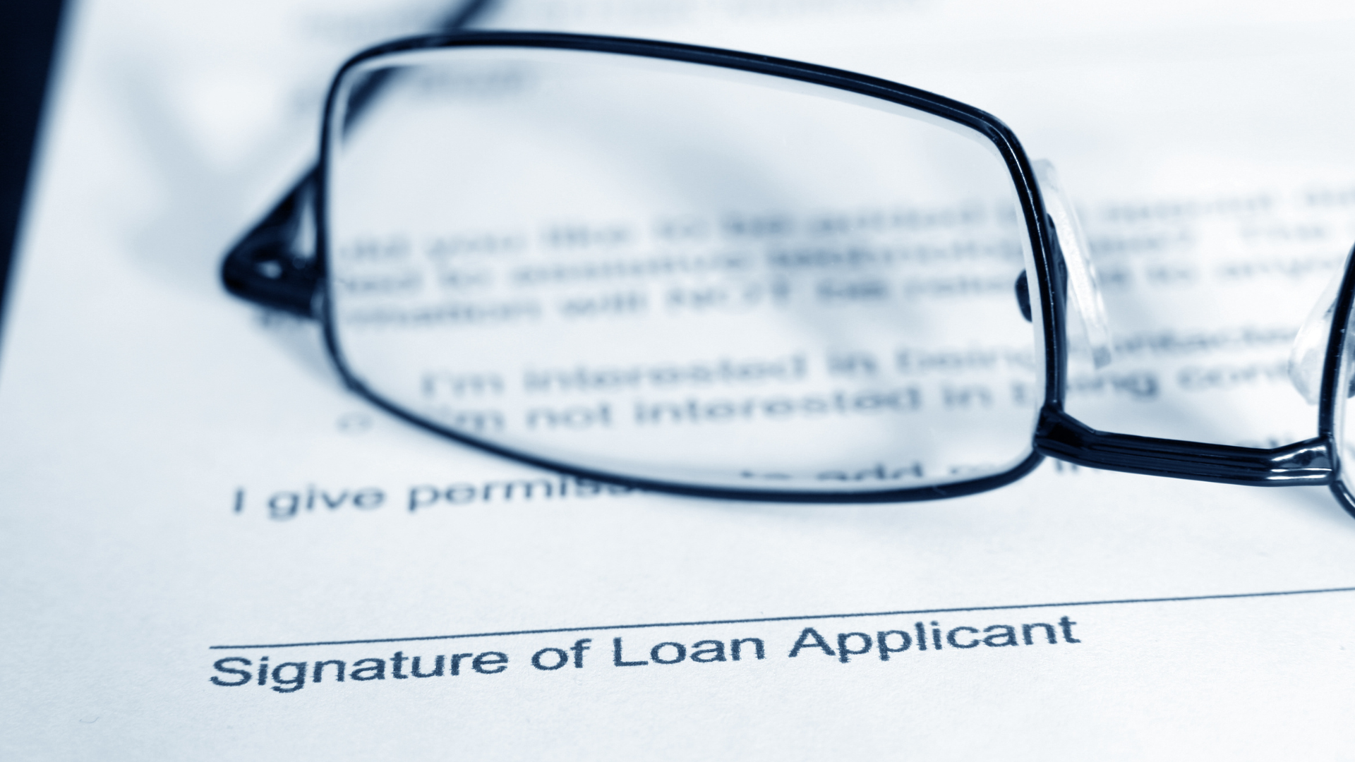 A pair of glasses sitting on top of a loan application