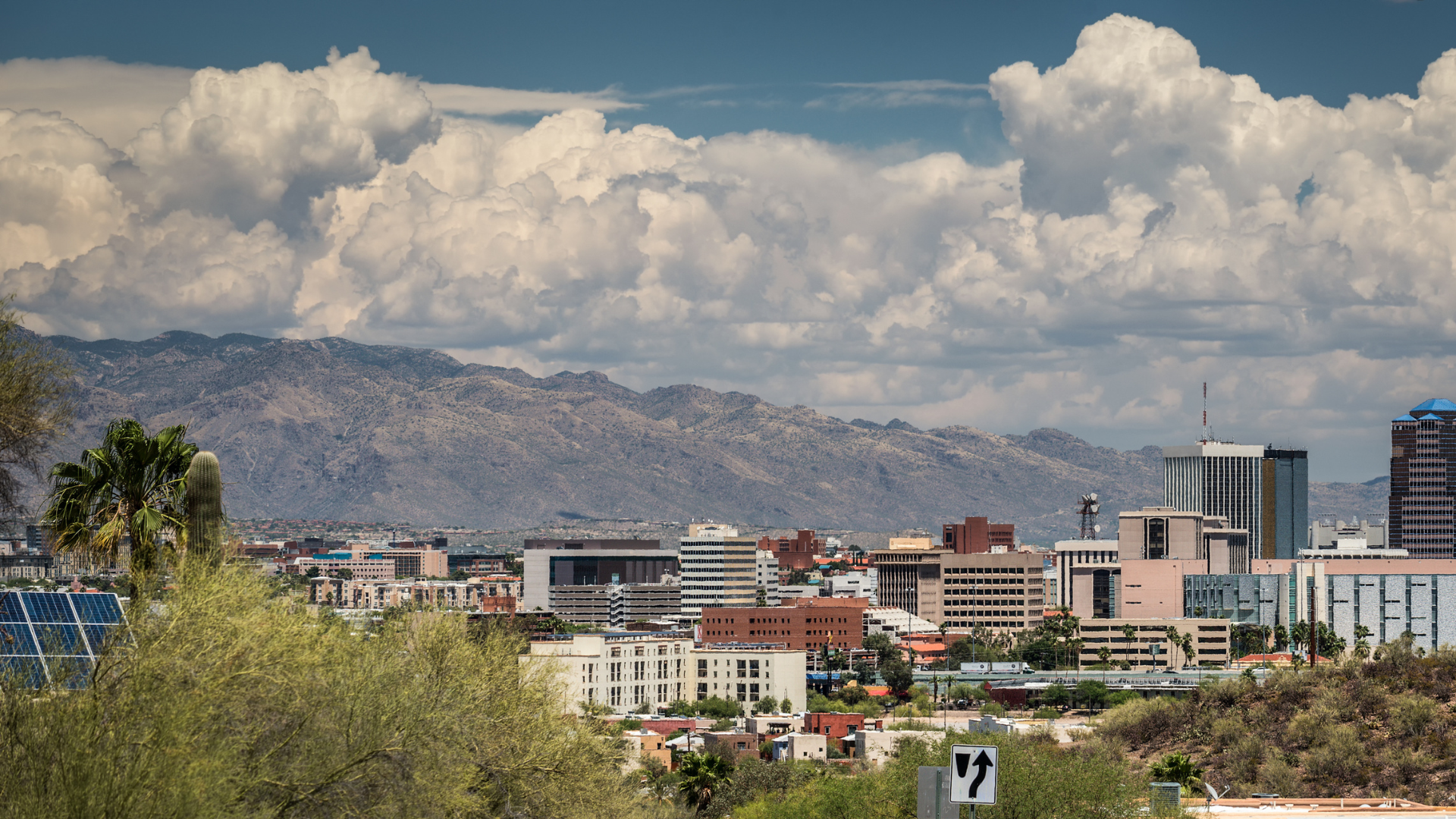A city with mountains in the background and clouds in the sky